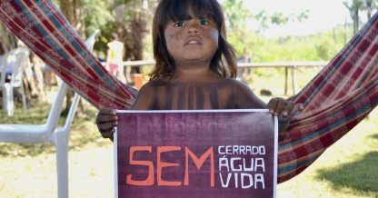 Menina indígena segurando uma faixa